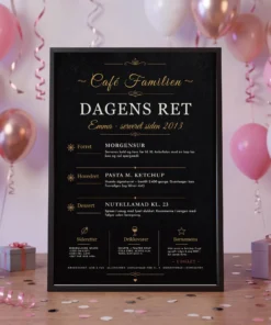Dagens ret plakat til konfirmation – sort menukort med konfirmandens navn og sjove retter, i sort ramme på festbordet mellem rosa balloner